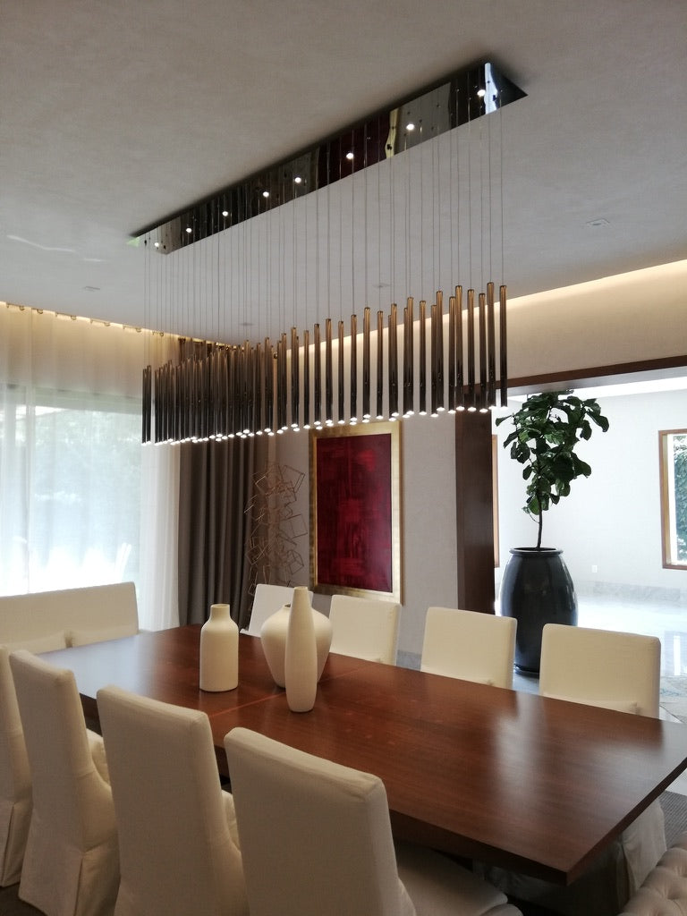 Lámpara colgante moderna iluminación sobre mesa de comedor con sillas blancas y decoración minimalista