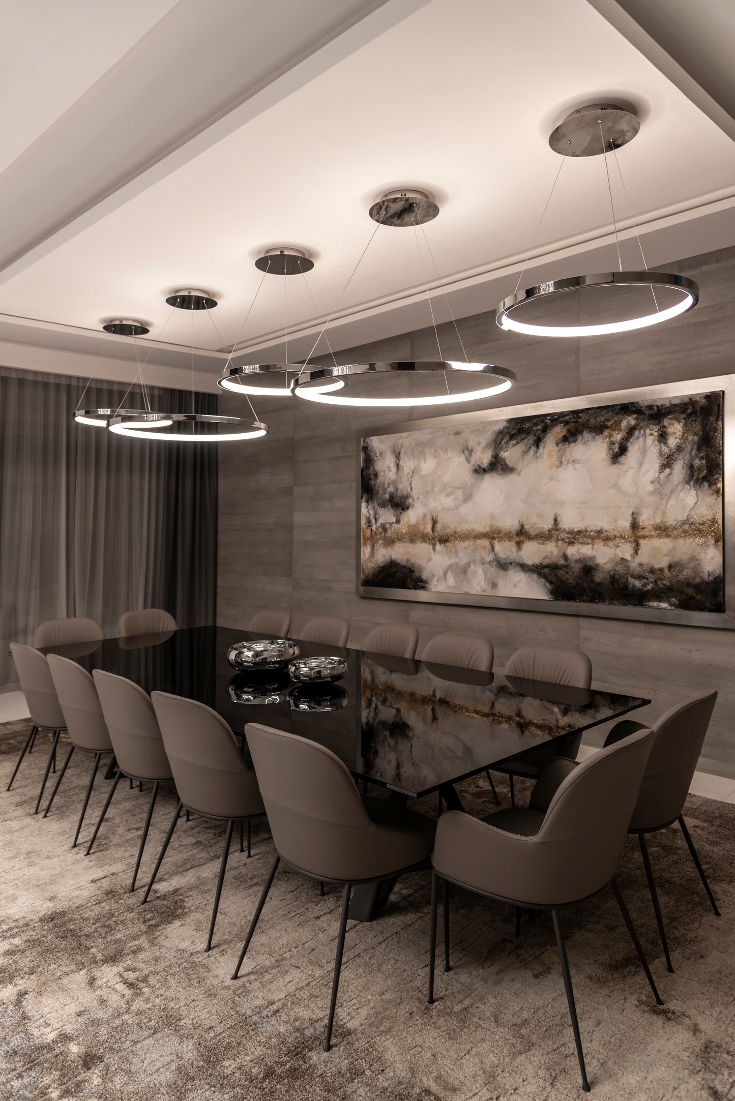 Comedor moderno con mesa negra, sillas beige y lámparas colgantes circulares LED
