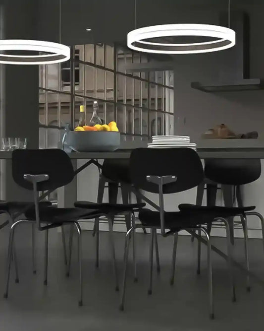 Lámpara colgante LED circular moderna sobre mesa de comedor con sillas negras en interior elegante