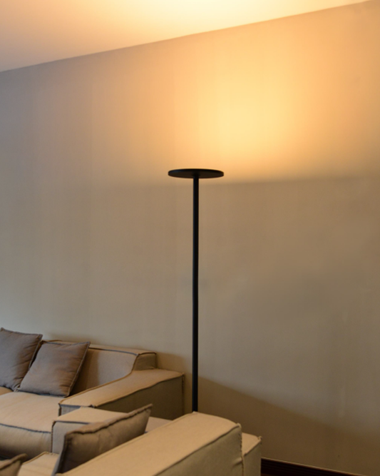 Lámpara de pie moderna negra en sala de estar con sofás beige, iluminación ambiental