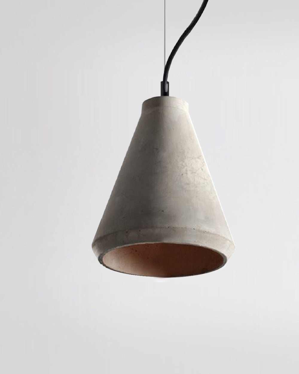 Lámpara colgante de concreto de estilo moderno sobre fondo blanco, iluminación decorativa.