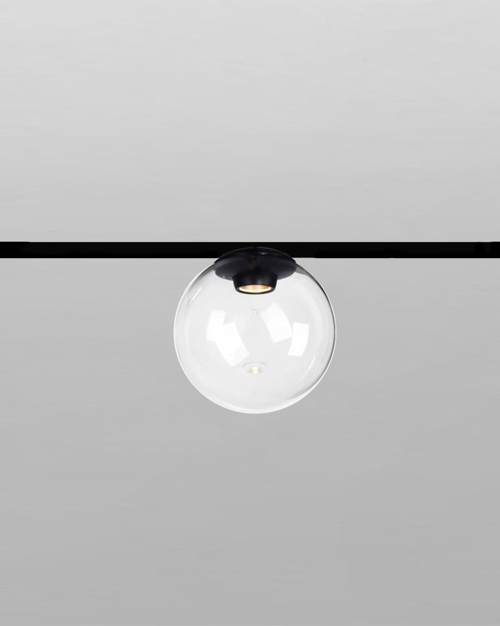 Lámpara colgante moderna de techo con esfera de vidrio transparente y base negra.