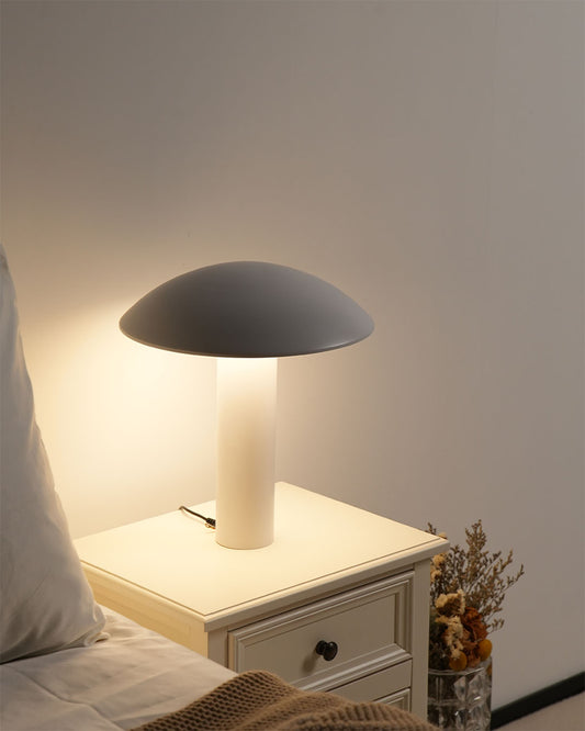 Lámpara de mesa moderna blanca sobre buró en dormitorio minimalista, iluminación cálida