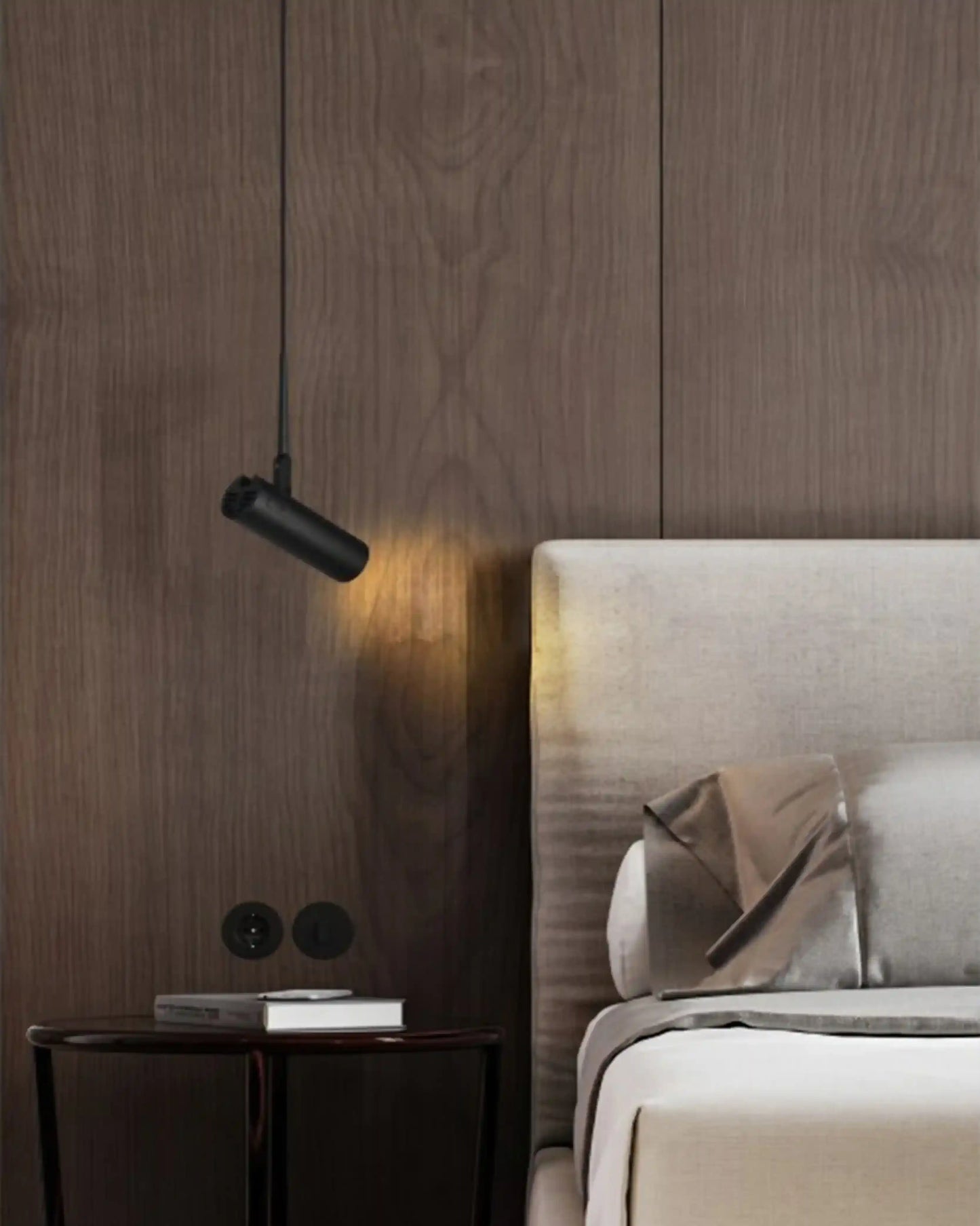 Lámpara colgante negra moderna junto a cama de diseño en dormitorio con pared de madera.