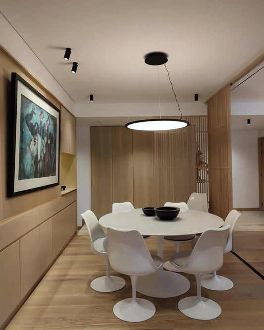 Comedor moderno con lámpara circular de techo, sillas blancas y decoración minimalista de Birot MX