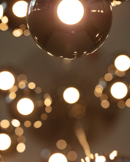 Lámpara de techo moderna dorada encendida con múltiples reflejos en ambiente interior.