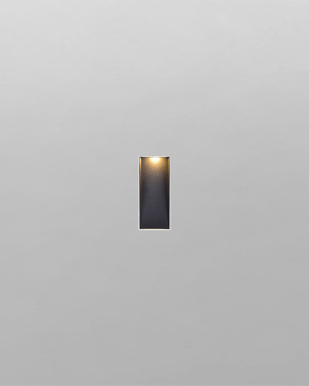 Aplique de pared rectangular blanco, moderno, encendido sobre fondo gris claro.