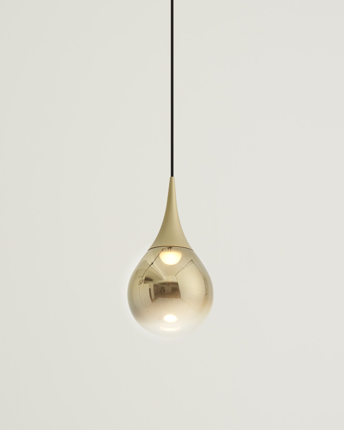 Lámpara colgante dorada de diseño moderno en forma de gota, ideal para interiores elegantes.