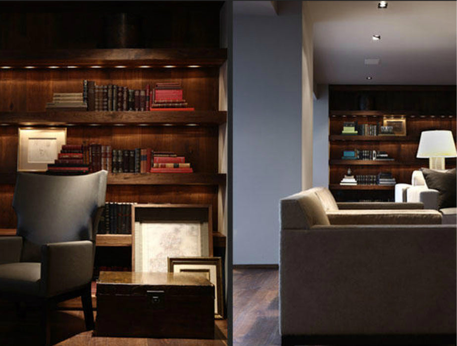 Sala moderna con estantes de madera, iluminación decorativa LED y sillones cómodos.