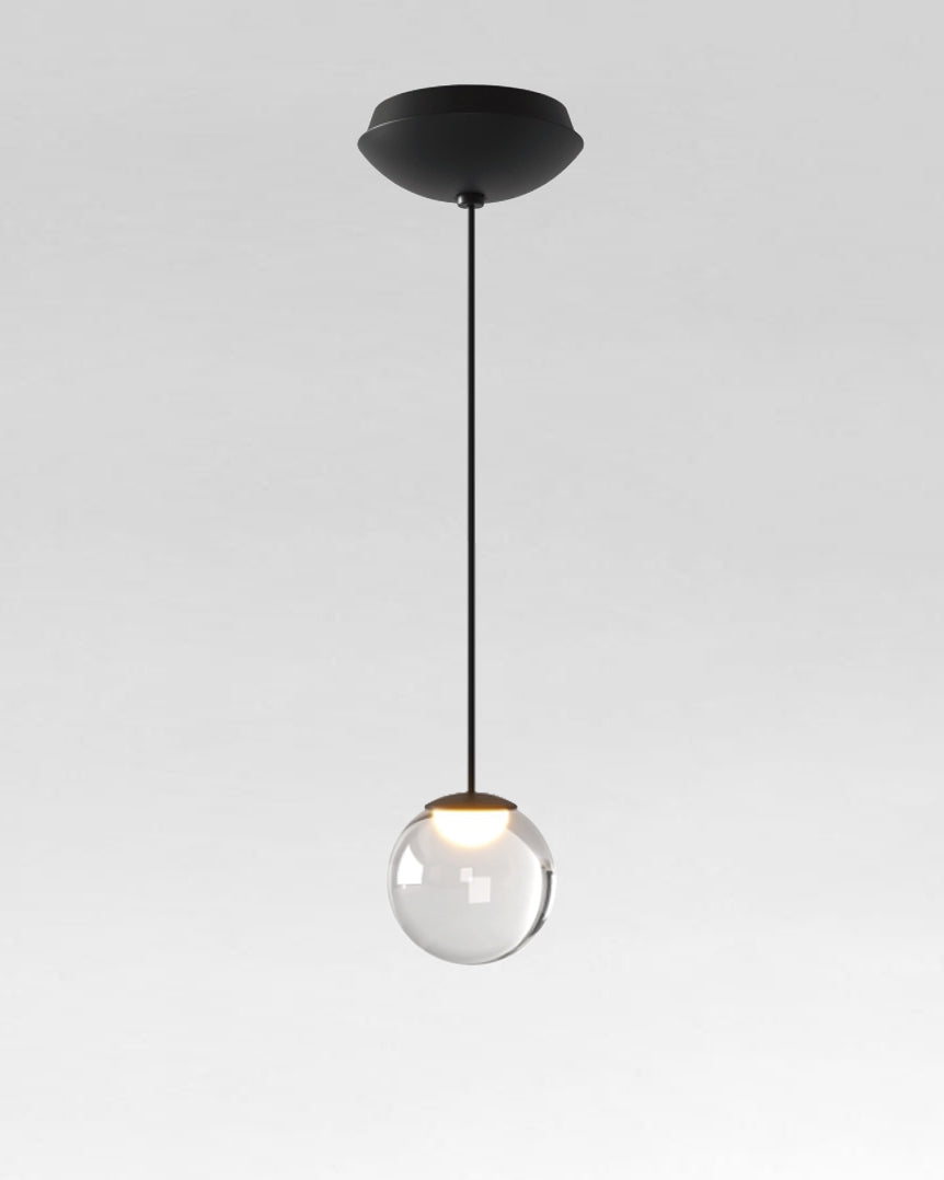 Lámpara colgante moderna con esfera de cristal transparente y base negra, iluminación elegante.