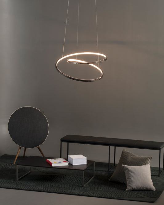 Lámpara de techo LED moderna sobre sala minimalista con banco, mesa y cojines grises