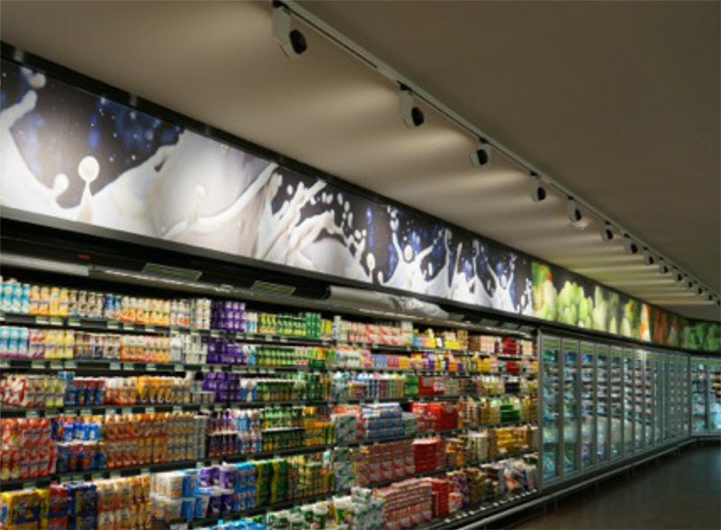 Estante de supermercado iluminado con productos refrigerados y focos de techo