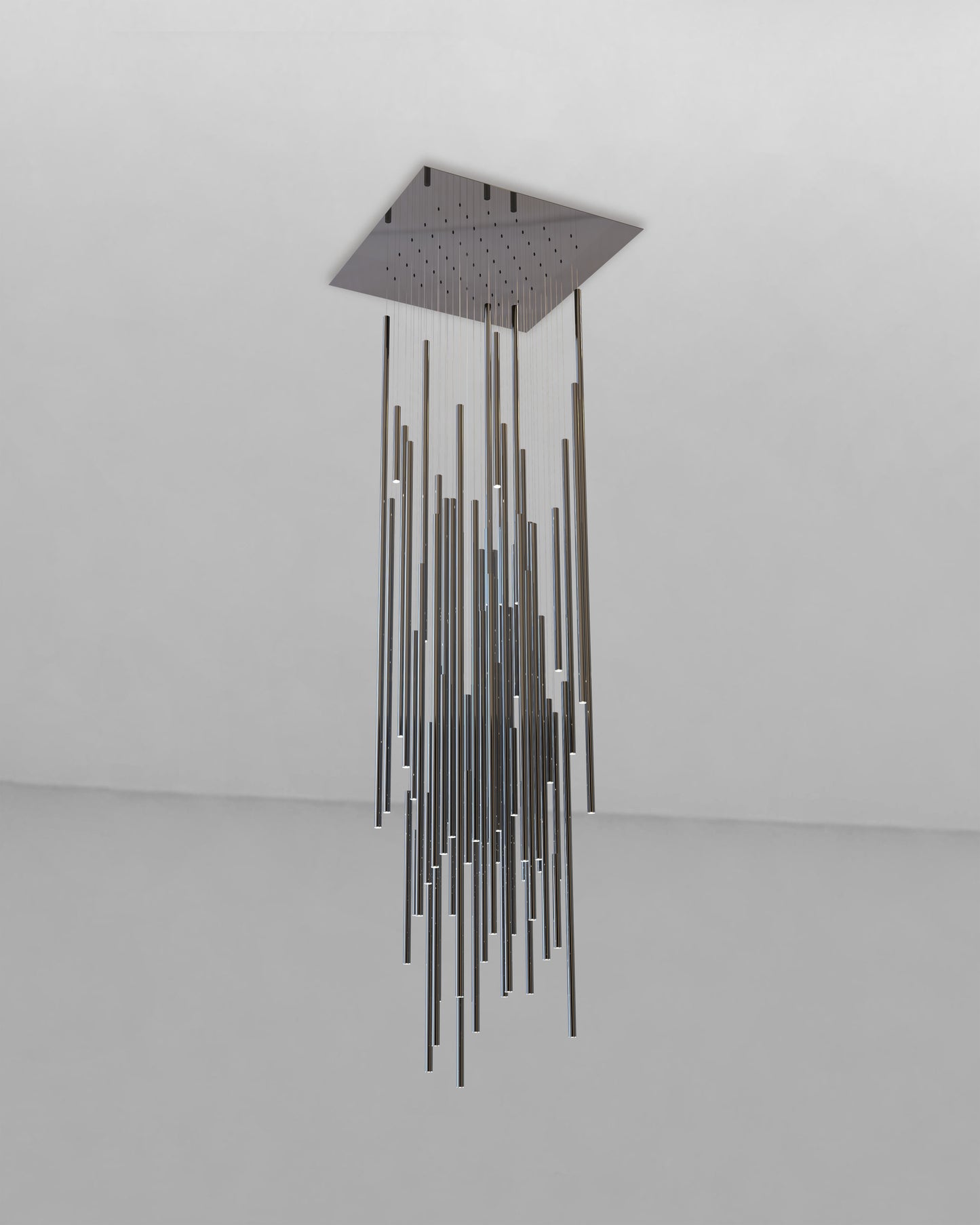 Lámpara colgante moderna de tubos metálicos largos en techo blanco, iluminación decorativa.