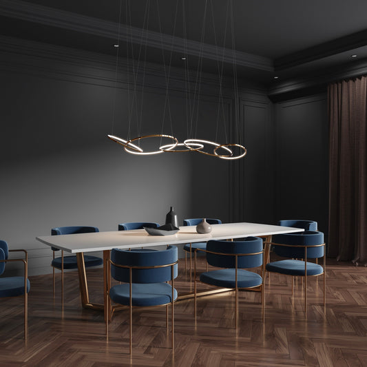 Lámpara colgante moderna sobre mesa de comedor y sillas azules en ambiente elegante