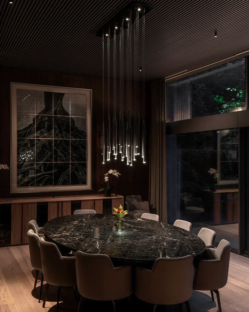 Lámpara colgante moderna sobre mesa ovalada de mármol en comedor elegante iluminado