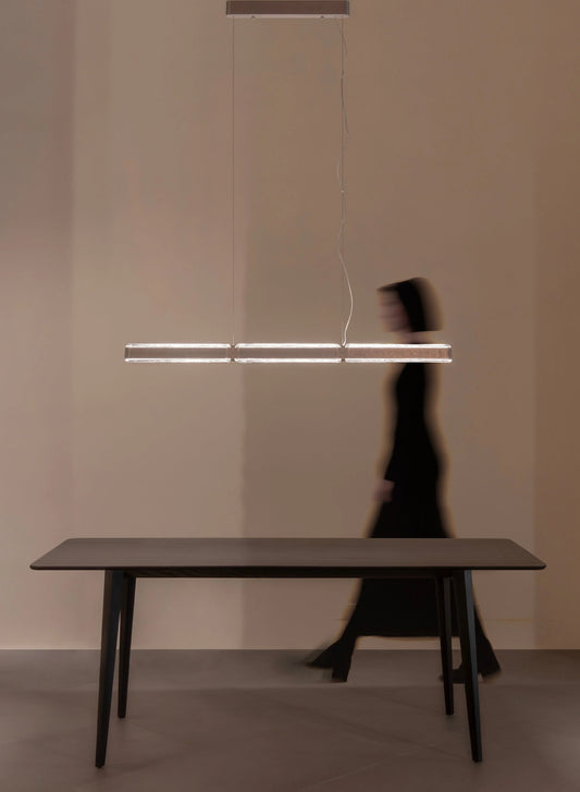 Luminaria colgante moderna sobre mesa de comedor minimalista, ambiente elegante