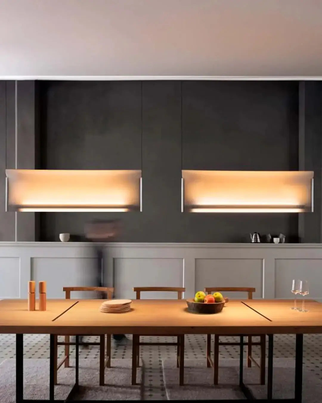 Lámparas colgantes modernas iluminando comedor elegante con mesa de madera y sillas