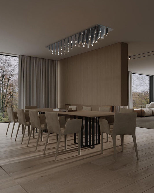 Lámpara colgante moderna de techo sobre mesa de comedor en sala minimalista con luz natural.