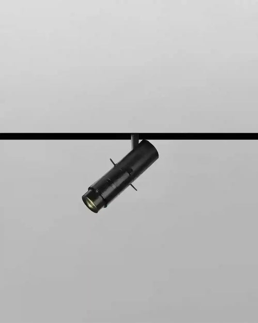 Luminario negro cilíndrico para riel, iluminación moderna Birot MX, fondo gris claro.