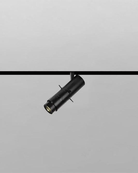 Luminario negro cilíndrico para riel, iluminación moderna Birot MX, fondo gris claro.