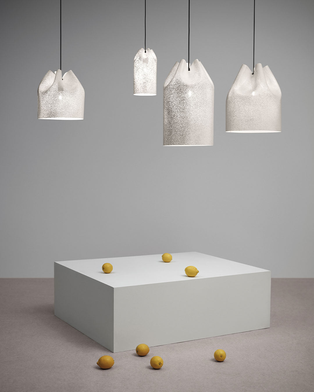 Lámparas colgantes de cerámica blancas Birot MX sobre base blanca con limones, ambiente minimalista