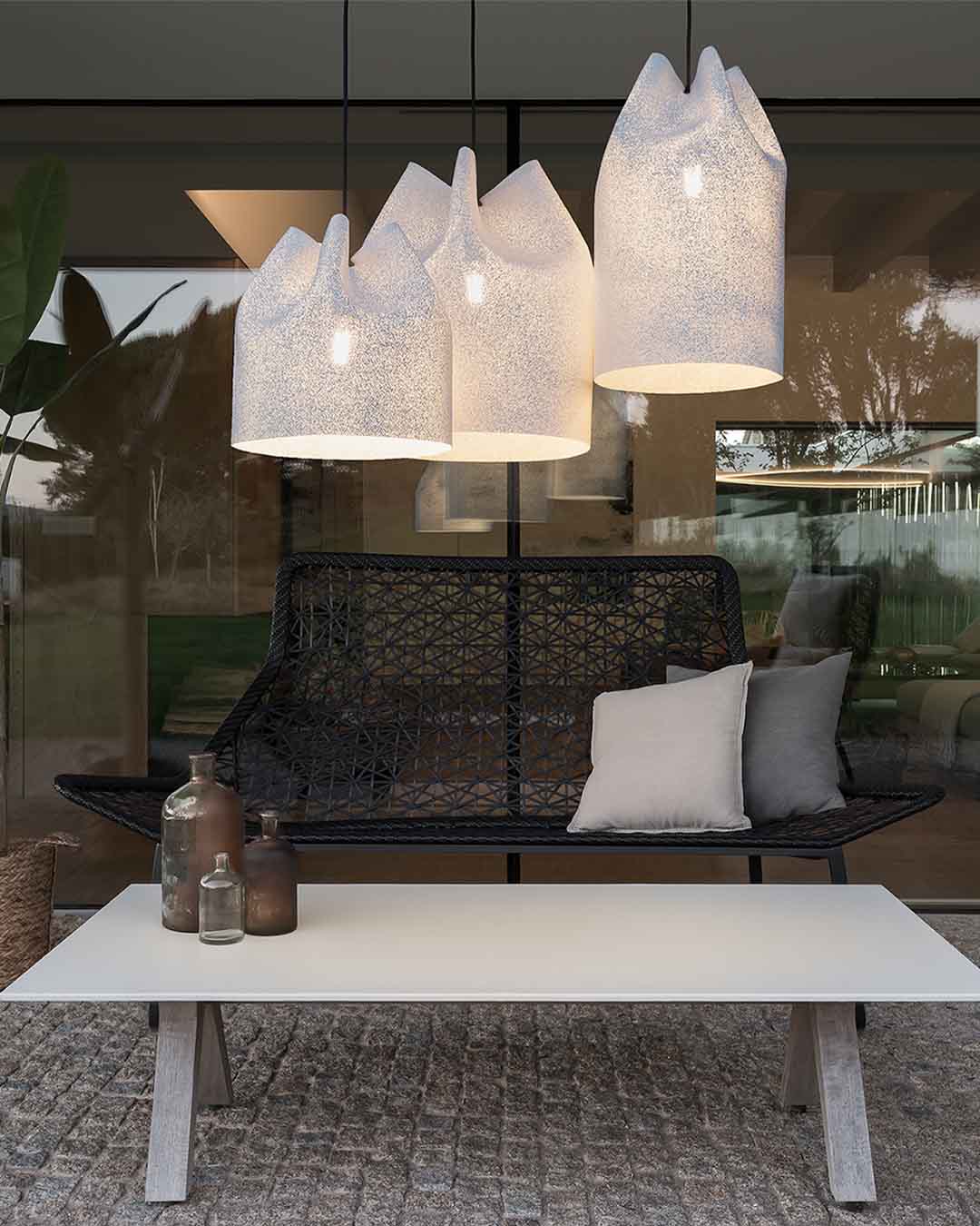 Lámparas colgantes modernas sobre banco y mesa en terraza, decoración de Birot MX boutique de iluminación