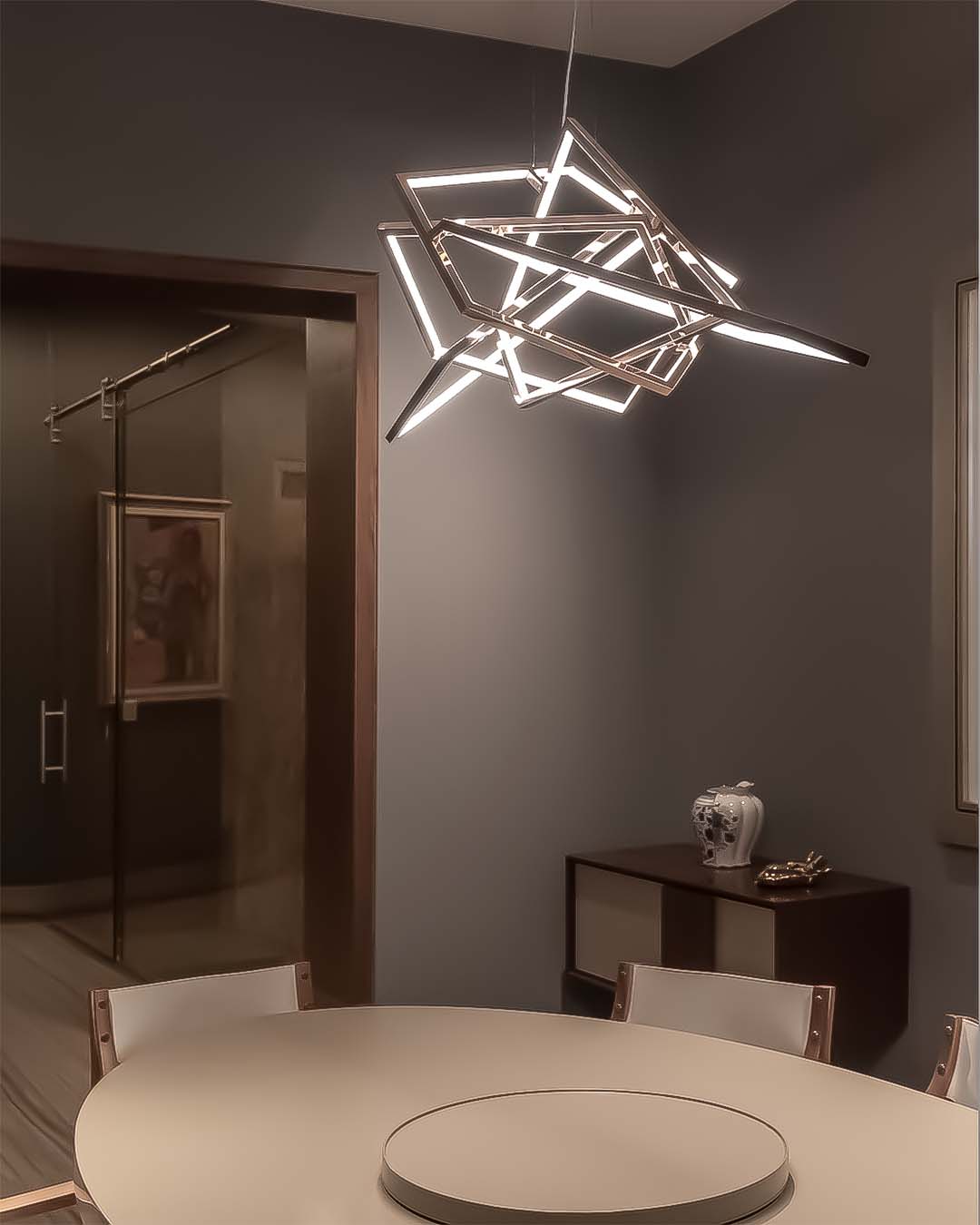 Lámpara colgante LED moderna sobre mesa de comedor en sala minimalista elegante.