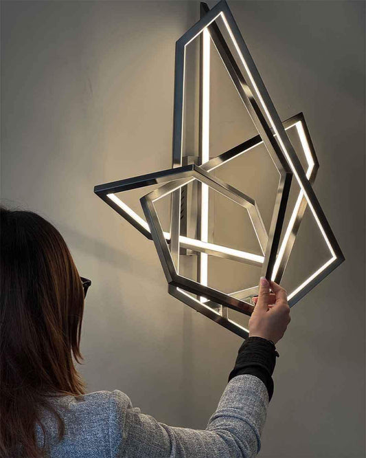 Lámpara de pared moderna geométrica encendida, mujer ajustándola, iluminación Birot MX