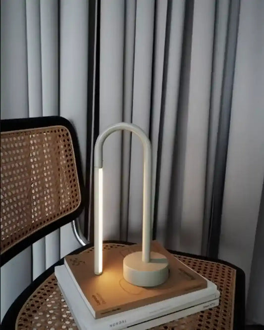 Lámpara de mesa minimalista blanca encendida sobre libros, decoración moderna Birot MX