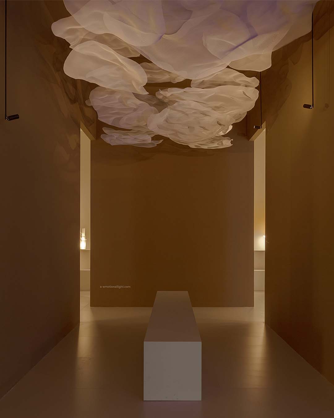 Instalación de luminaria decorativa tipo nube en techo de pasillo moderno, iluminación suave.
