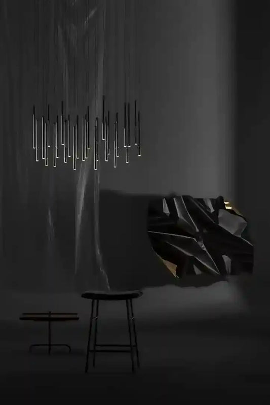 Lámpara colgante moderna de tubos negros en ambiente minimalista oscuro con mesa y banco