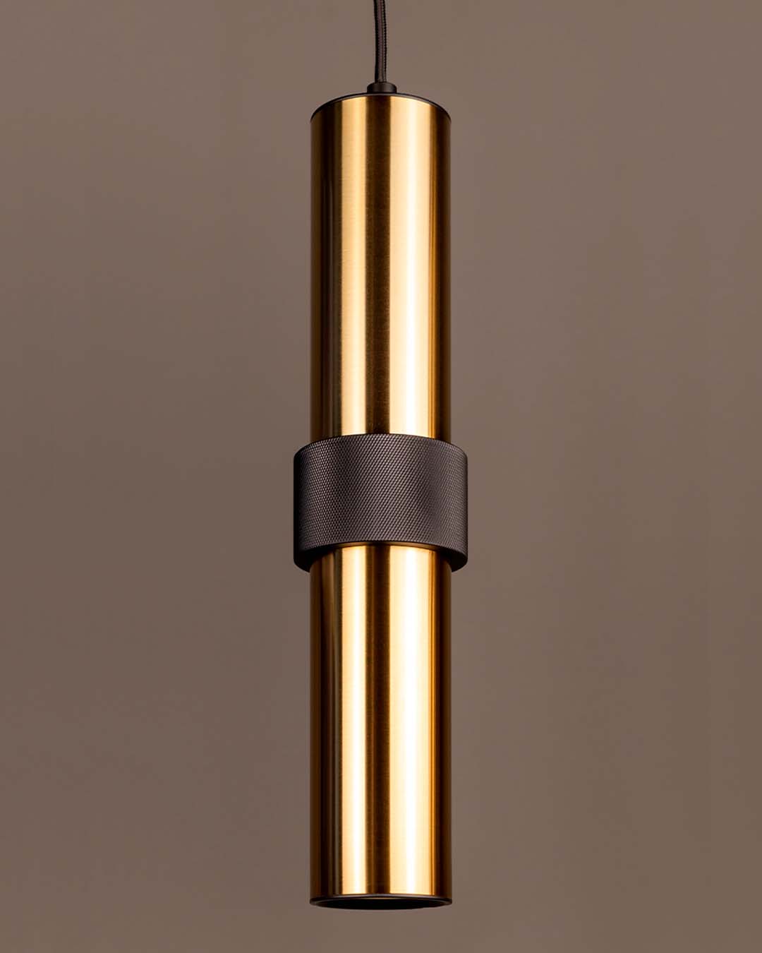 Lámpara colgante dorada de diseño moderno en interior minimalista, iluminación decorativa.
