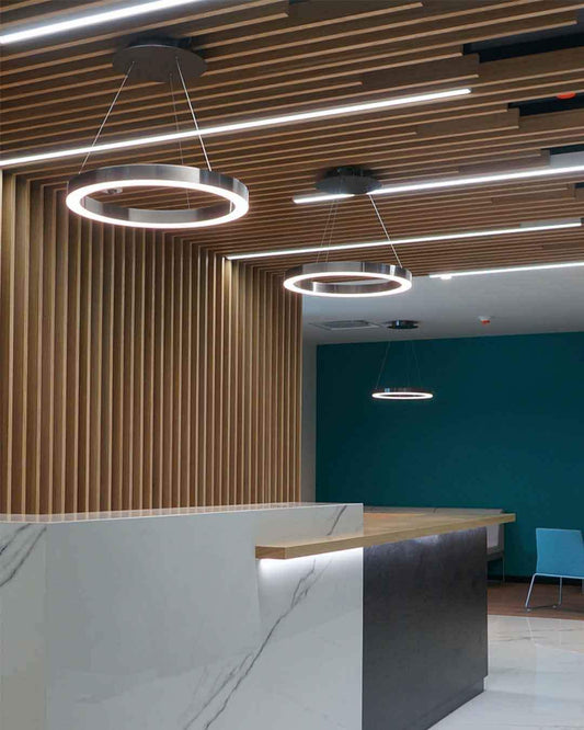 Lámpara circular LED colgante en recepción moderna, iluminación boutique Birot MX.