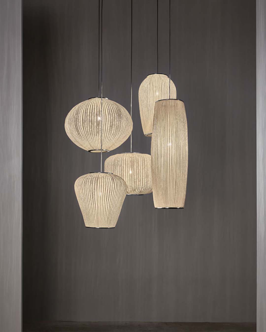 Lámparas colgantes de diseño moderno en tonos beige sobre fondo gris, iluminación decorativa.