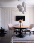 Comedor moderno con lámpara colgante de diseño, mesa redonda y sillas tapizadas, decoración elegante.