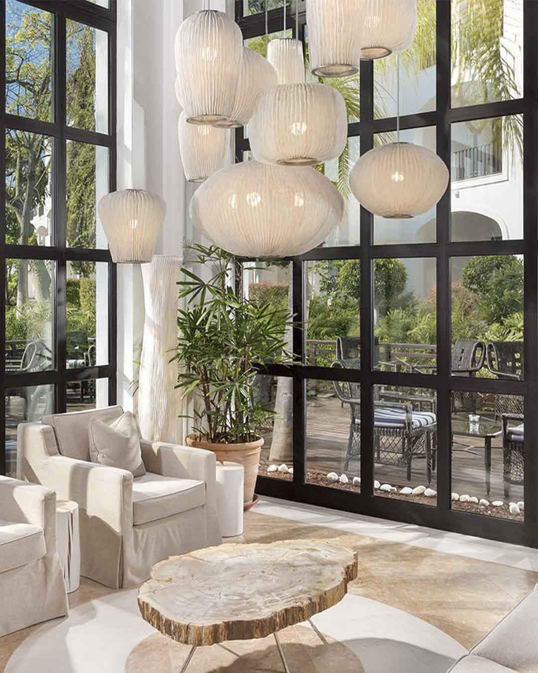 Lámparas colgantes de diseño en sala moderna iluminada, boutique Birot MX iluminación.