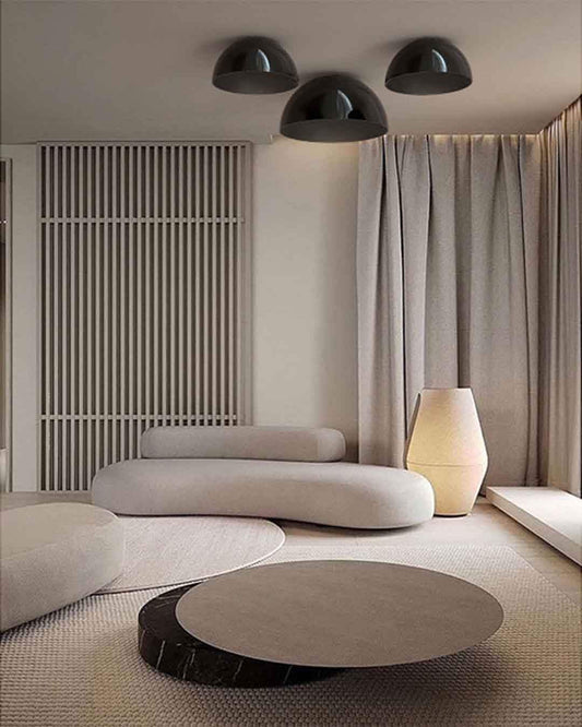 Sala minimalista con lámparas de techo modernas, sofá curvo y mesa baja, Birot MX iluminación.