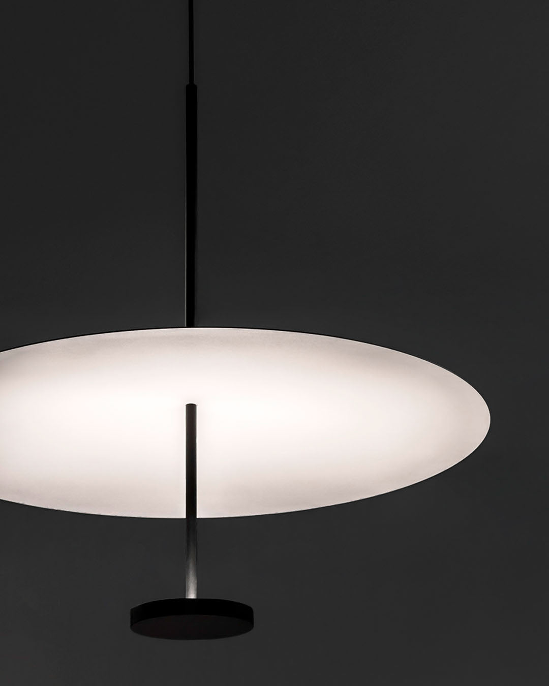 Lámpara colgante moderna de disco blanco encendida sobre fondo oscuro, Birot MX iluminación.