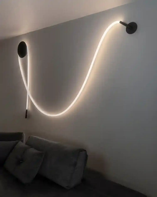 Lámpara LED de pared curva sobre sofá gris, iluminación moderna en sala de Birot MX