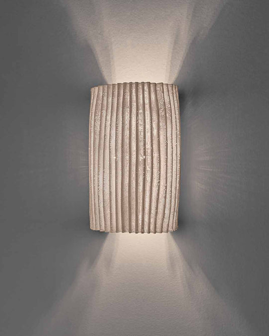 Aplique de pared Gea de a-emotional light en malla de acero con luz bidireccional.