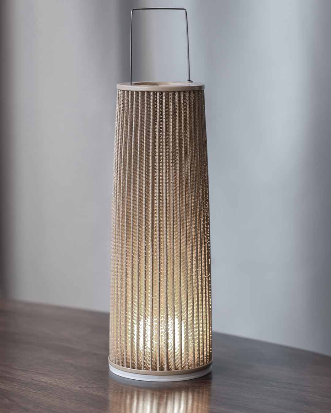 Lámpara de mesa decorativa moderna en madera encendida sobre superficie, boutique de iluminación Birot MX.