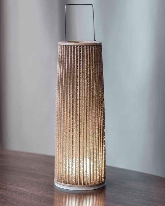 Lámpara de mesa decorativa moderna en madera encendida sobre superficie, boutique de iluminación Birot MX.