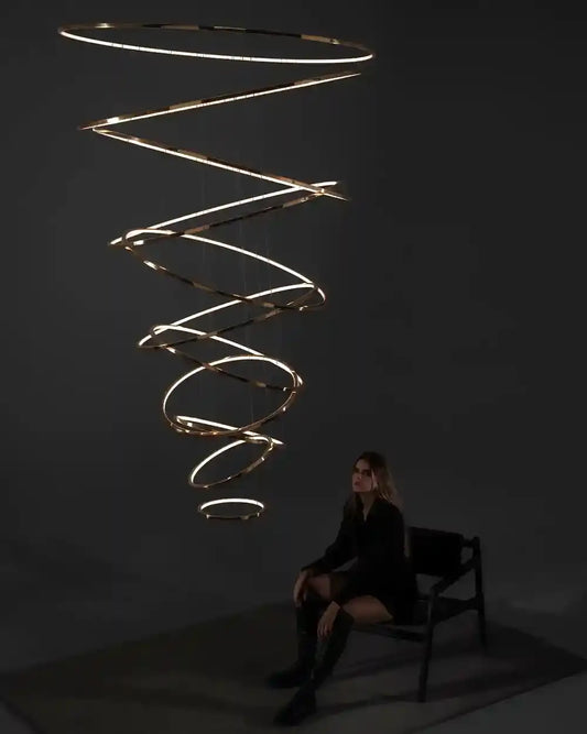 Lámpara colgante moderna en espiral encendida sobre banco, boutique de iluminación Birot MX