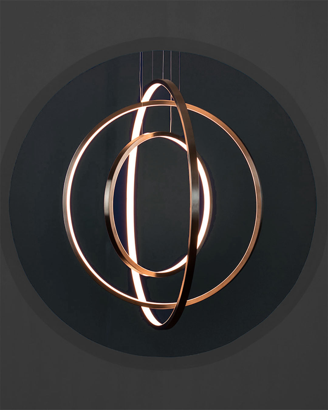 Lámpara colgante moderna con aros LED dorados sobre fondo oscuro, iluminación decorativa.