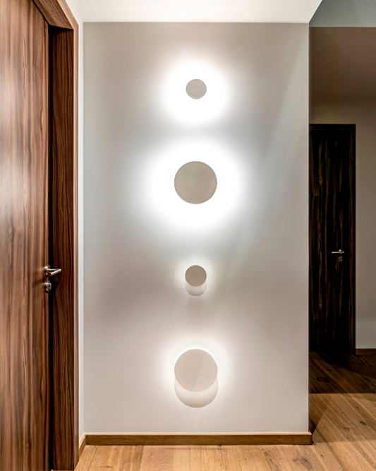 Instalación de luminarias circulares modernas en pared de pasillo interior minimalista