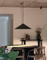 Lámpara colgante negra moderna sobre mesa de comedor con sillas de madera