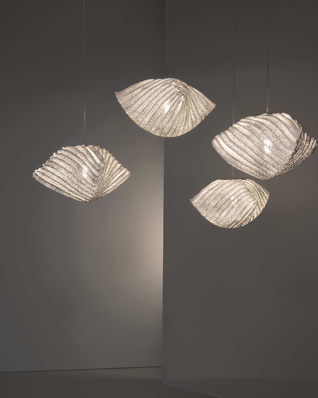 Lámparas colgantes modernas de vidrio texturizado iluminando un ambiente minimalista