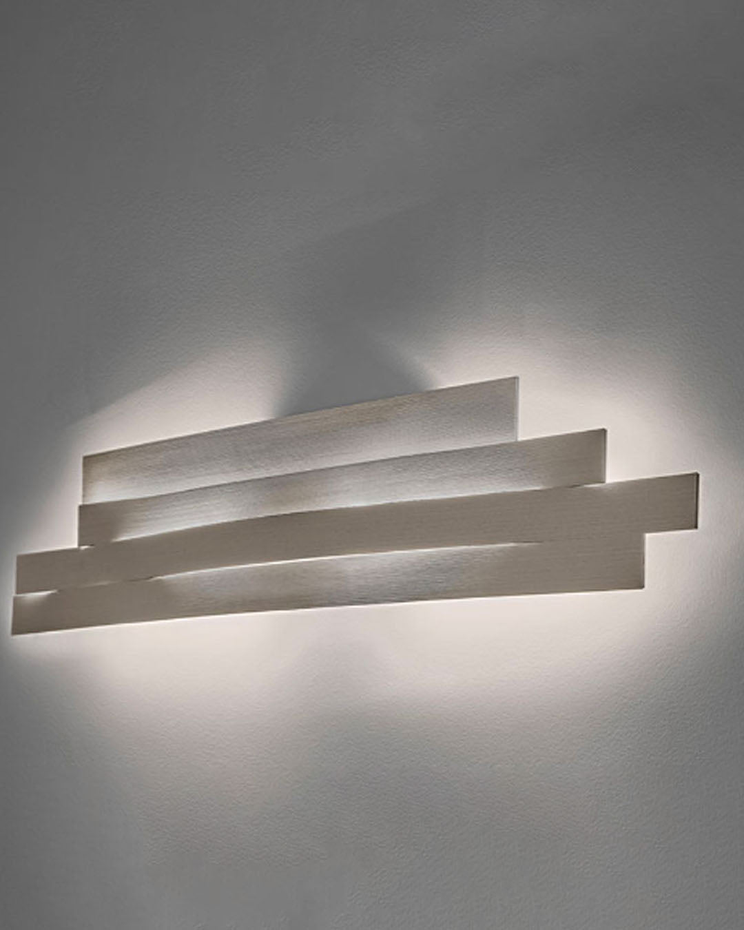 Aplique de pared moderno blanco iluminando fondo gris, diseño minimalista de iluminación Birot MX