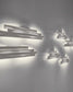 Apliques modernos de pared blancos encendidos en pared blanca, boutique de iluminación Birot MX