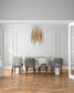 Lámpara colgante moderna dorada sobre comedor elegante de seis sillas en interior minimalista.